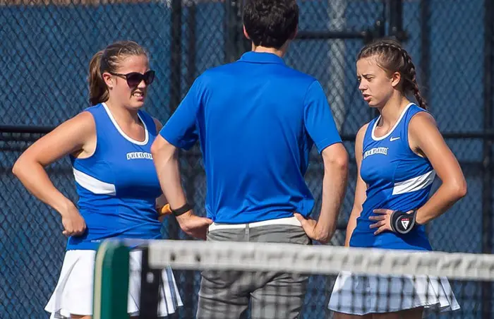two tennis players and their coach