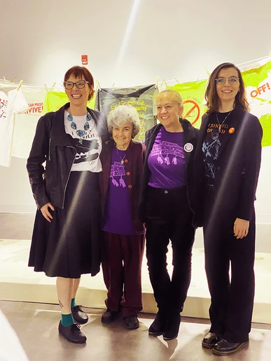 Gathering for a group photo in front of history-tracking t-shirts hung on a clothesline are (from left): Dr. Megan Urban, Kipp Dawson, Dr. Jessie Ramey and Catherine Evans.