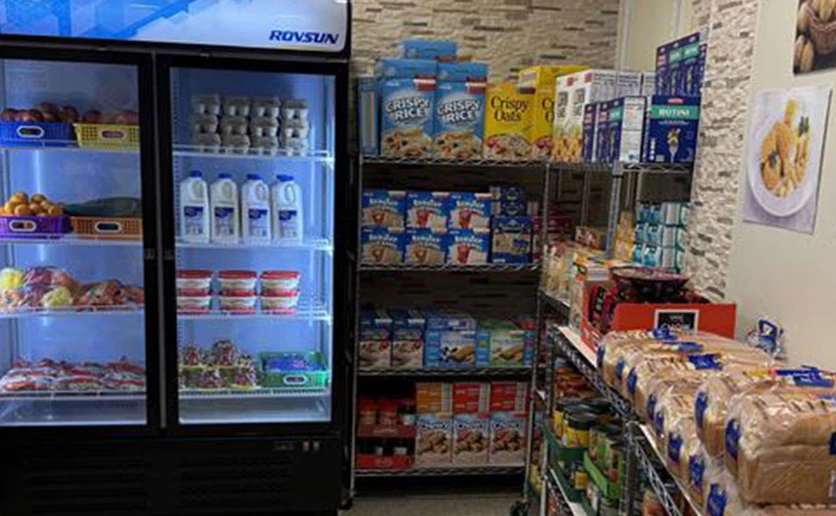 shevles stocked with food supplies and a refrigerator full of cold food items 