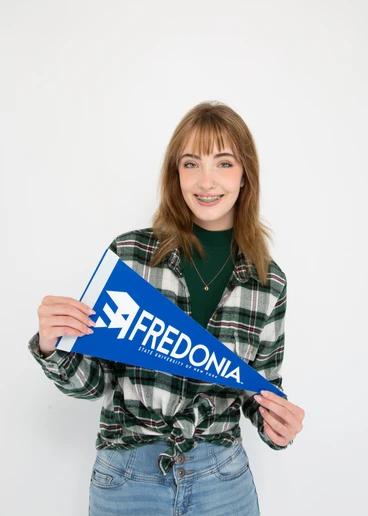 Fredonia student Caitlyn Hampe smiling and holding a FRED sign