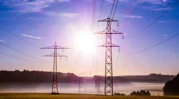 Energy transmission lines with bright sunlight behind