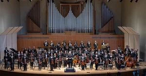 orchestra members standing on King Concert Hall stage