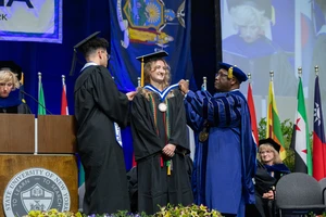 Mia Piede receives Lanford Presidential Prize medallion from President Kolison