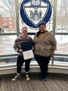 Madison Ghosen holding certificate with Nixon Hall Residence Director Heather Williams.