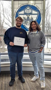 Ryan Packard holding certificate and Eisenhower Hall Residence Director Christian Taber.