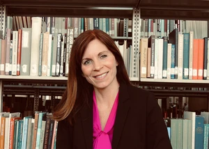 Dr. Emily VanDette in front of bookshelves