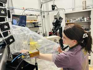 Isabelle Price places the sample holder with geological thin sections at the end station for synchrotron X-ray analysis.  