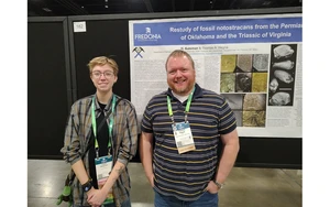 Jasper Bateman and Associate Professor Tom Hegna in front of their poster presented at the conference.