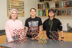 Gathering in a Houghton Hall lab are (from left): Mia Enders, Isabelle “Belle” Price and Nicky Flores.