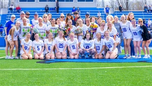 lacrosse students on the field with flowers and photos