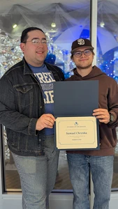 Samuel Chrenka accepts the Student of the Month award for March from McGinnies Hall Director Ronny Nissen