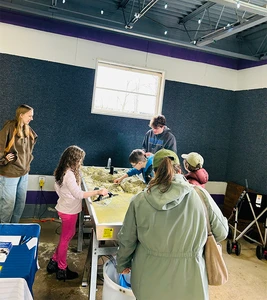 SUNY Fredonia students lead children through exploration of the stream table at the Gem and Mineral Show.
