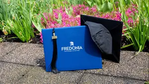 photo of diploma cover and mortarboard