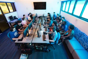 Members of the eSports team gather in the eSports Lounge in Schulz Hall, either playing games and others following the swift action.