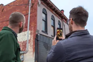 student takes a photo of buildings