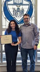 Anna Sheehan holding certificate standing with staff member who nominated her for the award