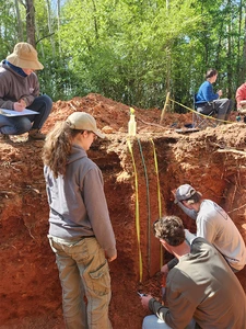 students examining soils in a pit