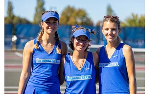 three seniors standing in uniform on tennis court by Travis Bernhard