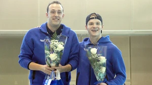 Seniors Alexander Wright and Aaron Burkett holding flowers