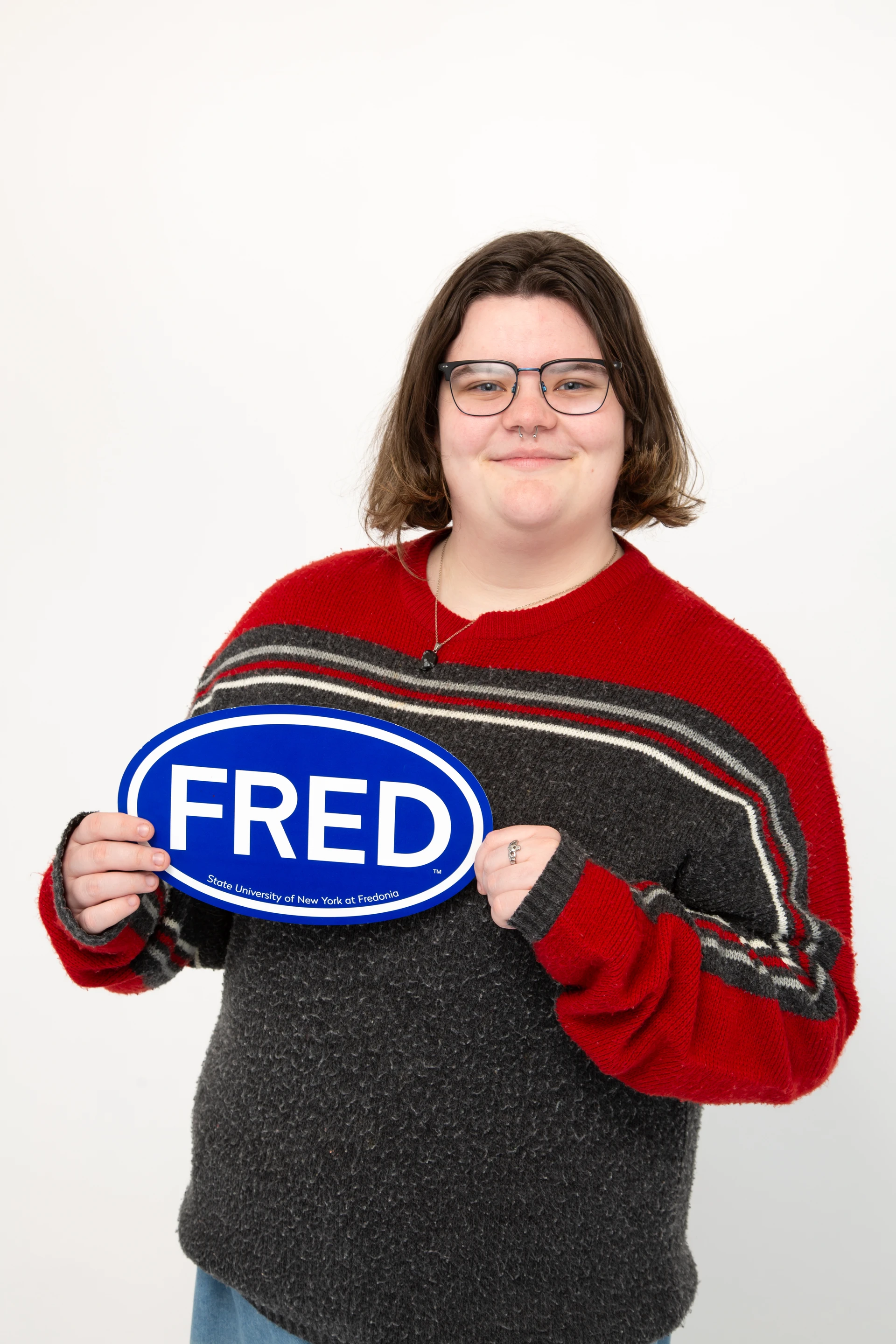 School of Music student Megan Kidby holds up a FRED sign and smiles for the camera