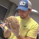 A Fredonia student in a lab holding a brain