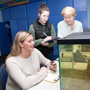 Psychology students working with a professor in a lab