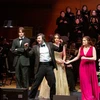 students performing on stage with orchestra and chorus