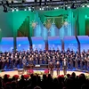 chorus and directors on stage in King Concert Hall with holiday decorations