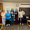 new honor society members and officers standing in front of society banner