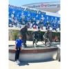 Connor West outside standing next to hockey player statues