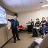 Dr. Rob Deemer at the screen pointing out music to students