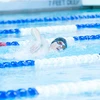 man swimming freestyle by Travis Bernhard
