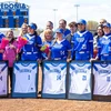 senior softball players with framed jerseys and their families 