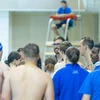 swimmers standing with coach by Travis Bernhard