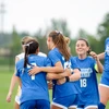 women soccer players celebrating on the field by Riley Olson