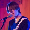 Student playing guitar and singing during battle of the bands