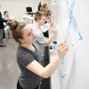 students drawing logos on a whiteboard in the front of a classroom, a degree in marketing, marketing degree, degree in marketing,  bachelor in marketing, marketing bachelor degree, jobs in marketing, business marketing, marketing degree, degree in marketing, A degree in marketing