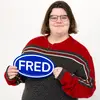 School of Music student Megan Kidby holds up a FRED sign and smiles for the camera