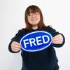Morgan Brown smiling and holding a FRED sign